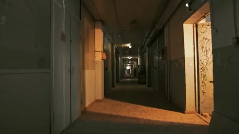 Very long, dark corridor with fluorescent lighting and an abandoned interior. Stock Footage 287915363