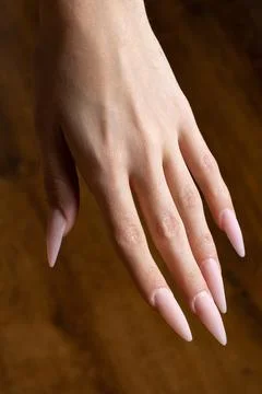 Very long extended nails on a thin hand. Stock Photos