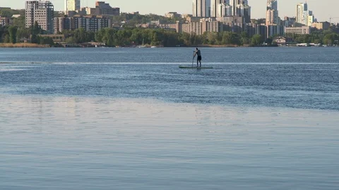 Very Long Shot, Young Guy Standing Sip on Sup on the River on the City's Stock Footage 89405638