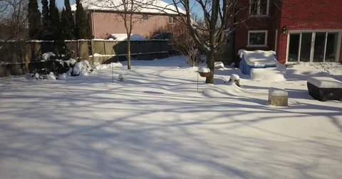 Very low altitude drone flight in pristine snow covered suburban backyard. Видео 83794472