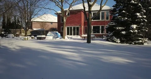 Very low altitude drone flight in pristine snow covered suburban backyard. Видео 83795026