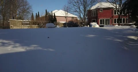 Very low altitude drone flight in pristine snow covered suburban backyard. Видео 83795898