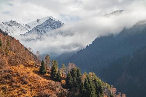 Very low clouds touch the peaks of the Almaty autumn mountains Stock Photos