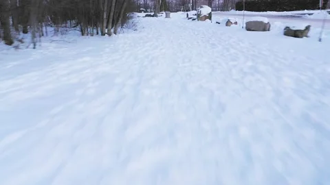 Very low drone shot backing up while following pedestrian tracks in the whit Stock Footage 163981637