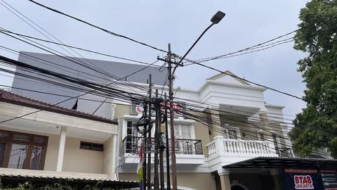 Very messy electrical cables in front of a house in Jakarta on June 02, 2024. Stock Photos