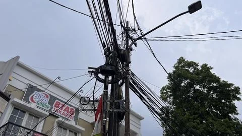 Very messy electrical cables in front of a house in Jakarta on June 02, 2024. Stock Photos