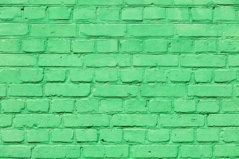 A very old brick wall completely painted with green paint. Stock Photos