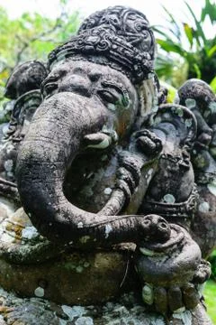 Very old elephant shape stone sculpture covered with moss and lichens in Bali Stock Photos