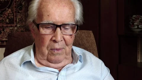A very old man with glasses is looking at something interesting on a laptop. Vídeos de archivo 137121700