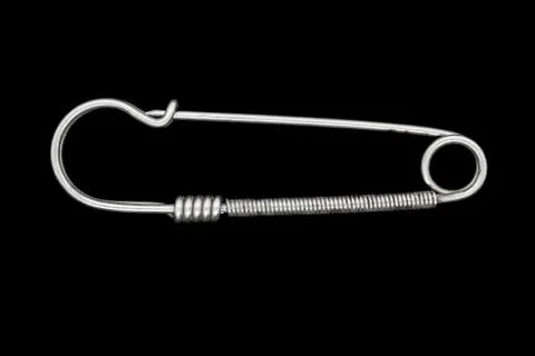Very old, rusty and vintage metal safety pin isolated on black background Stock-Fotos