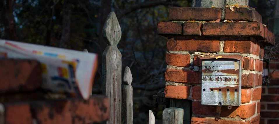 Very old rusty post box on the brick column. Stock Photos