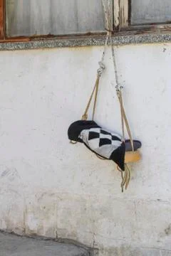 Very old swing in front of the wall Stock Photos
