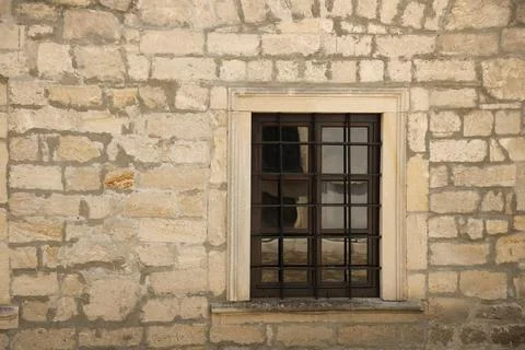 Very old window in brick stone wall of castle or fortress of 18th century. Full Stockfoto's