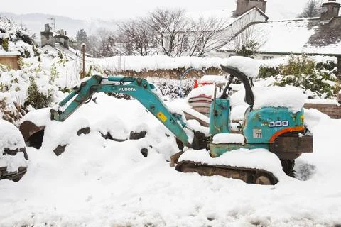A very small mini digger in snow, Ambleside, Lake District, UK. Stock Photos