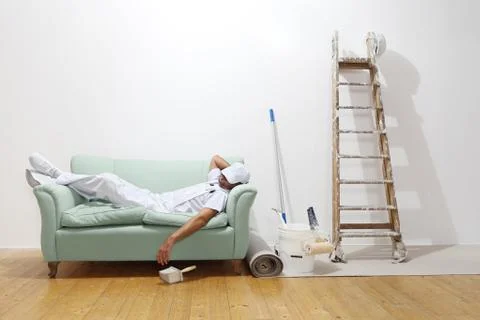 Very tired worker concept, painter man sleeps on the couch Stock Photos