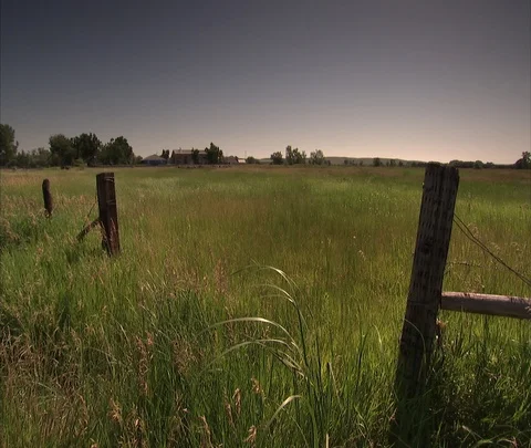 Very wide shot of flat field with coal train in the distance Stock Footage 86690459