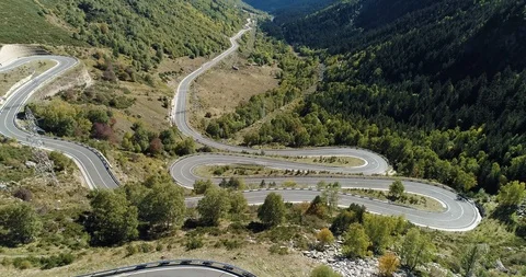 Very windy road up mountain, multiple turns leading down valley drone aerial 4k Stock Footage 125756848
