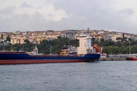 Vessel navigating the Bosphorus Strait with hillside cityscape in the background Stock Photos