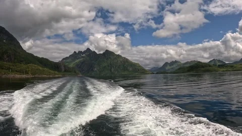 Vessel passage over dark glassy fjord water with cloud reflections in Lofoten Stock Footage 344753229