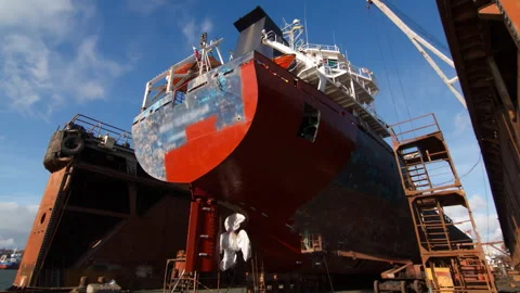 Vessel refurbishment dock, workers apply paint in fast-motion. Aerial view ship Stock Footage 258423086