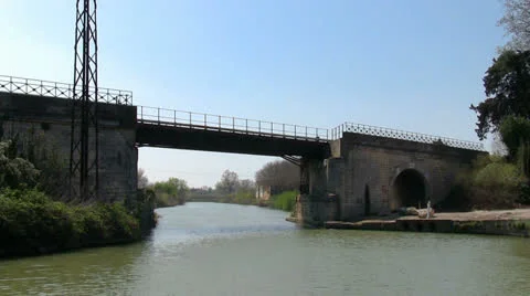 Vessel sails on the canal under the bridge in town Stock Footage 22704813