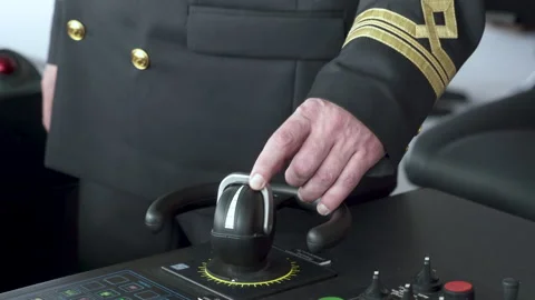 Vessel's bridge. Officer turns controller of bow thruster. Second mate controls Stock Footage 219013459