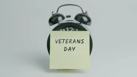 Veterans Day Text or Word on Yellow Note Paper Sticking onto Black Clock Stock Footage 299726523