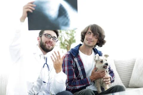 Veterinarian showing an x-ray to the owner of the dog. Stock Photos