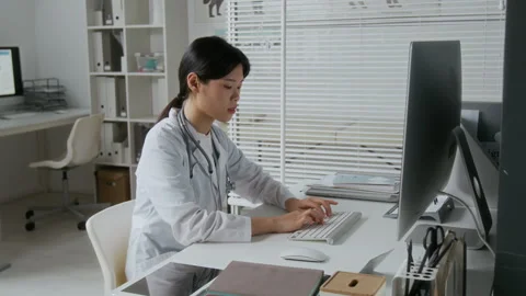 Veterinarian Typing on Keypad of Desktop Computer while Looking at Screen Stock Footage 303153908