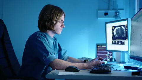 A veterinarian typing something on his computer that shows the magnetic Stock Footage 236457356