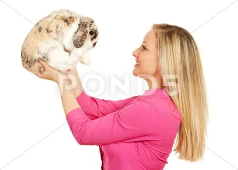 Veterinarian: woman holds bunny in air Stock Photos