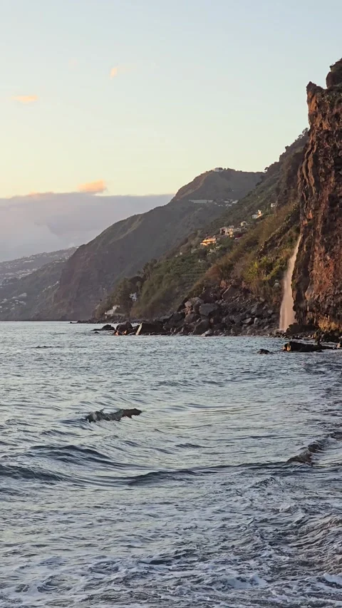 Véu da Noiva waterfall flows from Madeira’s cliffs into the Atlantic at sunset.  Stock Footage 310024517