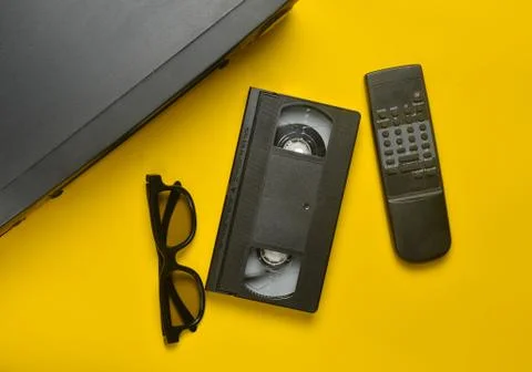 Vhs player, video cassette, 3d glasses, tv remote on a yellow background. Obs Stock Photos
