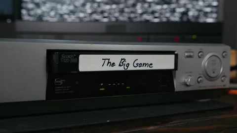 VHS Tape Inserted and Ejected from a VCR. Male Hand. Labeled "The Big Game" Stock Footage 137434200