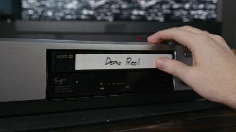 VHS Tape Inserted and Ejected from a VCR. Male Hand. Labeled "Demo Reel" Stock Footage 137434417