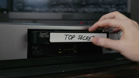 VHS Tape Inserted and Ejected from a VCR. Male Hand. Labeled "TOP SECRET" Stock Footage 137434464