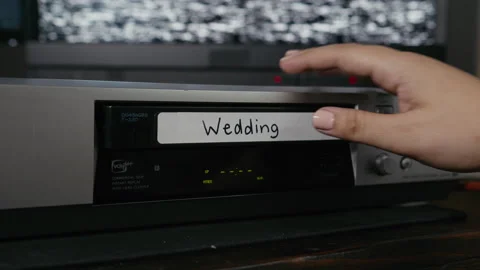 VHS Tape Inserted and Ejected from a VCR. Female Hand. Labeled "Wedding" Stock Footage 137441438