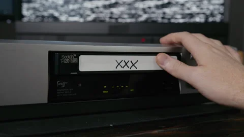 VHS Tape Inserted and Ejected from a VCR. Male Hand. Labeled "XXX" aka Porno Stock Footage 137443822