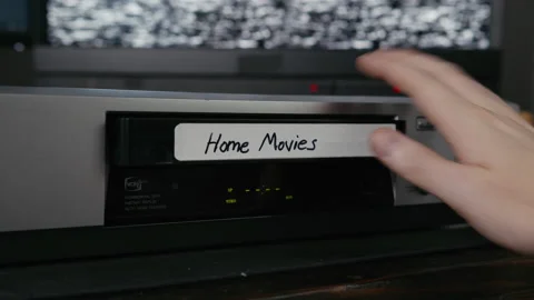 VHS Tape Inserted and Ejected from a VCR. Male Hand. Labeled "Home Movies" Stock Footage 137444049