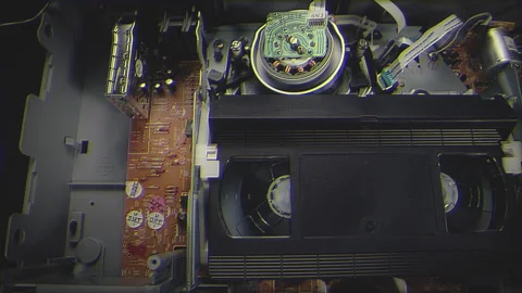 VHS Tape Inserted and Playing in a VCR Dolly Filter Stock Footage 253974854