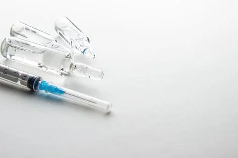 Vials and syringe on light table. Stock Photos