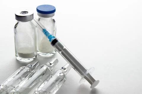 Vials and syringe on light table. Stock Photos