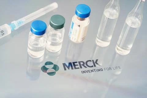 Vials of liquid on a white table and the logo of a large pharmaceutical compa Stock Photos