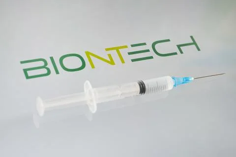 Vials of liquid on a white table and the logo biontech, large pharmaceutical  Stock Photos
