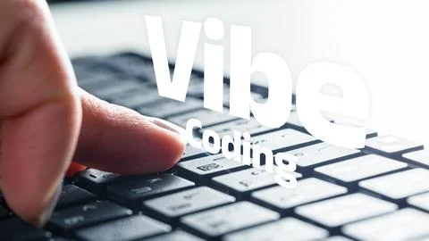 Vibe coding on a computer keyboard with a finger pressing a key Stock-Fotos