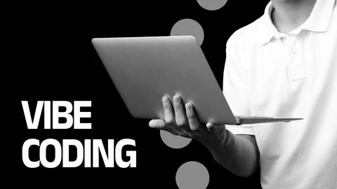 Vibe coding taking place with a person holding a laptop and focused on the Stock Photos