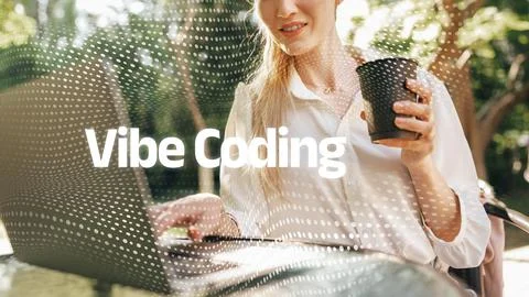 Vibe coding with a woman working on a laptop outdoors while holding a drink in Stock Photos