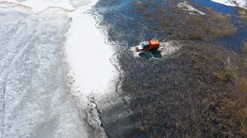 Vibrant 4x4 ATV forges a path through aquatic reeds in a waterlogged swamp Stock Footage 262631794