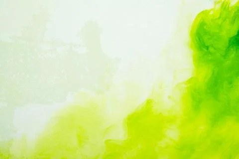 A vibrant abstract background featuring bright green and lime yellow ink or.. Stock Photos