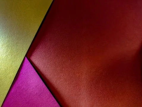 A vibrant abstract background with intersecting gold, red, and pink paper. .. Stock Photos